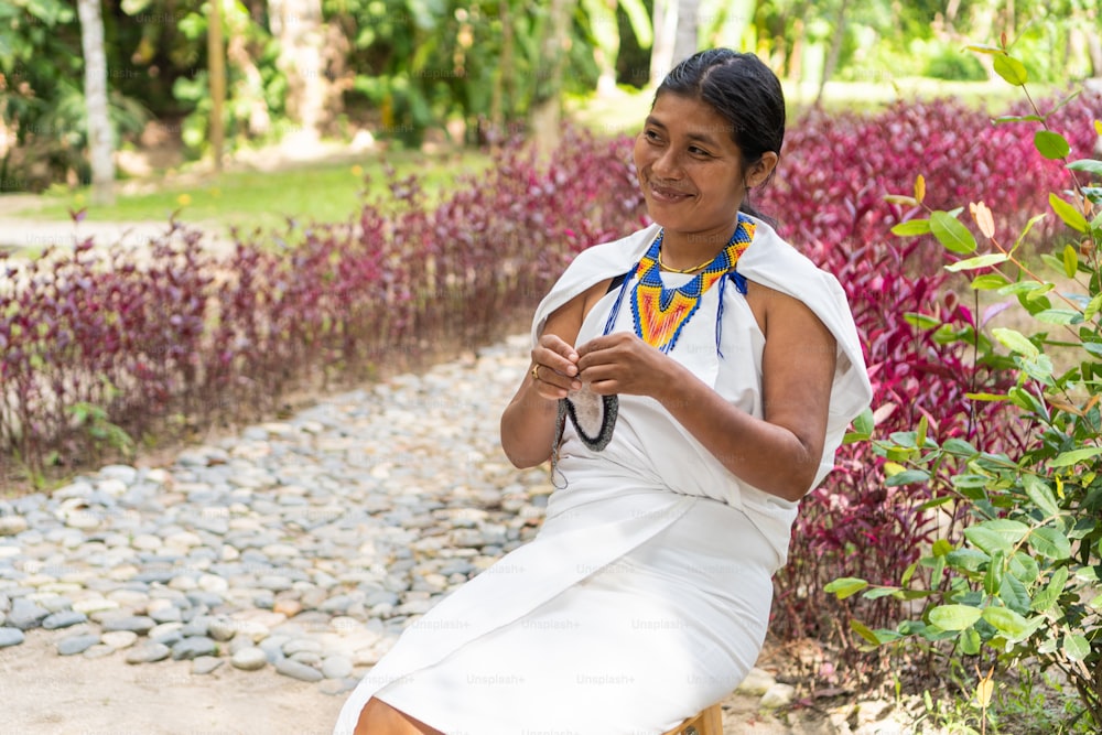 Indigenous woman from the Sierra Nevada de Santa Marta with traditional clothes weaving