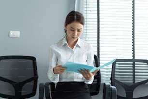 Asian beautiful woman applicant prepare for job interview in corporate. Attractive female sit on lined up chair, feel nervous while waiting for apply job with hr manager and practice speak with resume