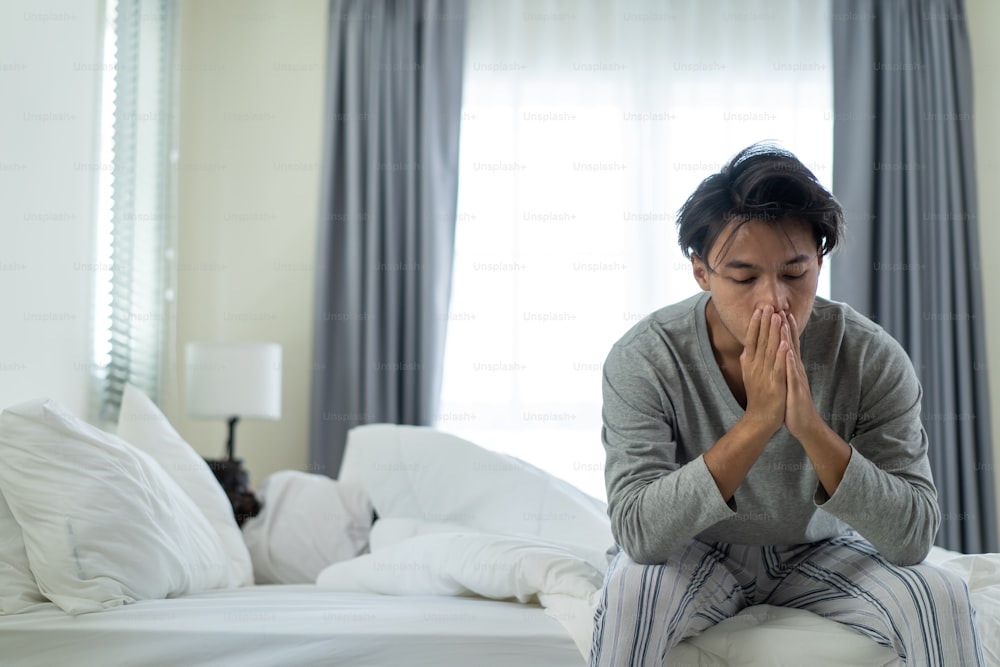 Asian young man feel angry girlfriend having conflict domestic problem. New marriage man and woman feel heartbroken for quarrel conflict while sit on bed in bedroom. Family problem-separation concept.