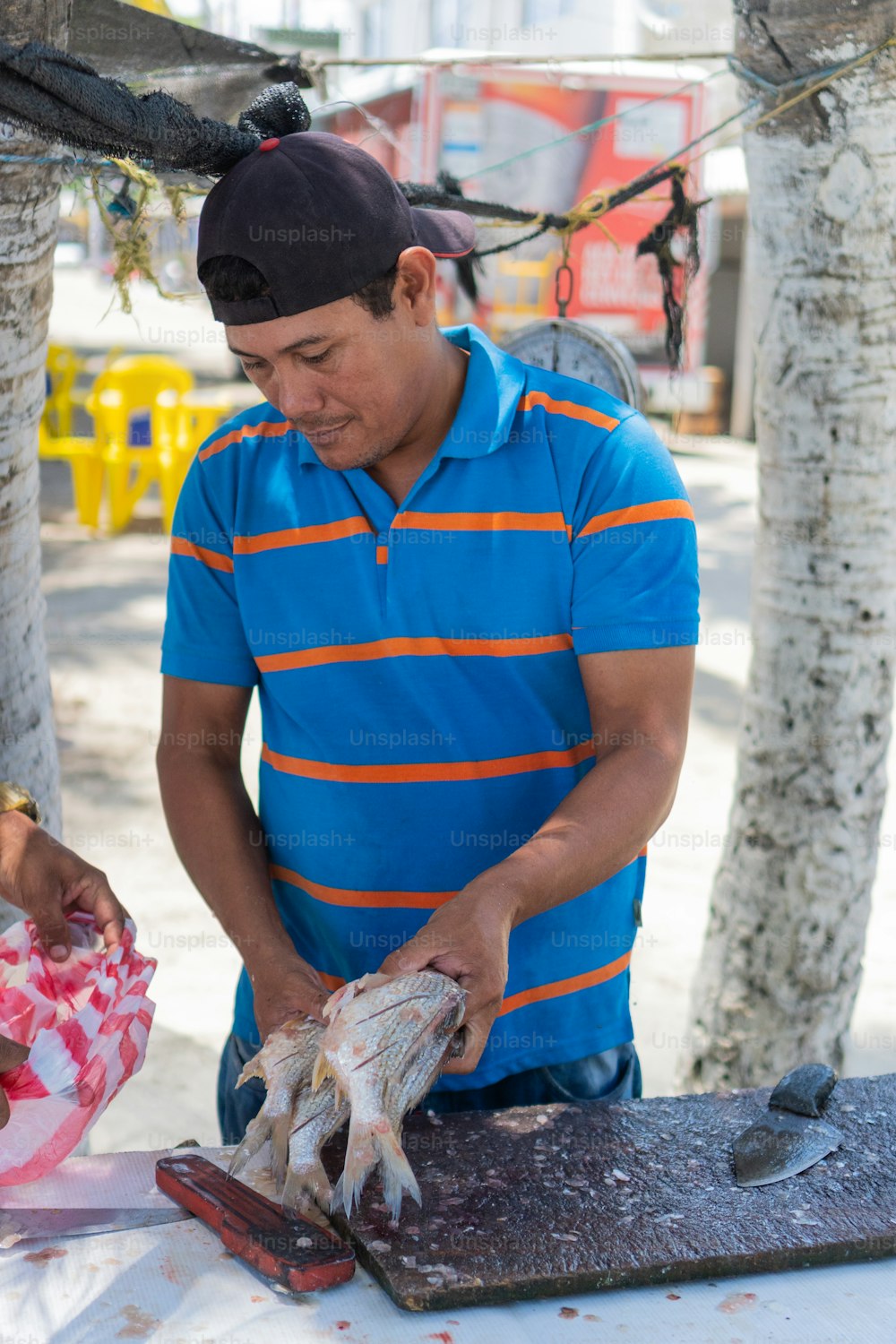 Lateinamerikanischer Mann bei der Arbeit auf dem Fischmarkt