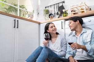 아시아의 젊은 신혼 부부는 집에서 부엌에서 함께 시간을 보낸다. 매력적인 낭만적 인 남자와 여자는 가족 관계 생활과 새 집으로 이사하는 것을 축하하기 위해 와인을 마신다.