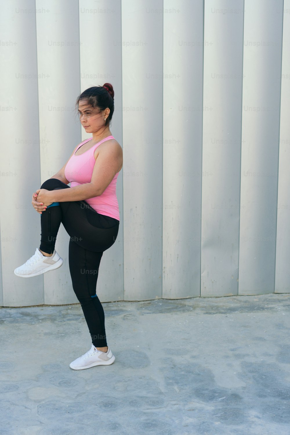 Latina woman in sportswear is doing warm-up exercise outdoors