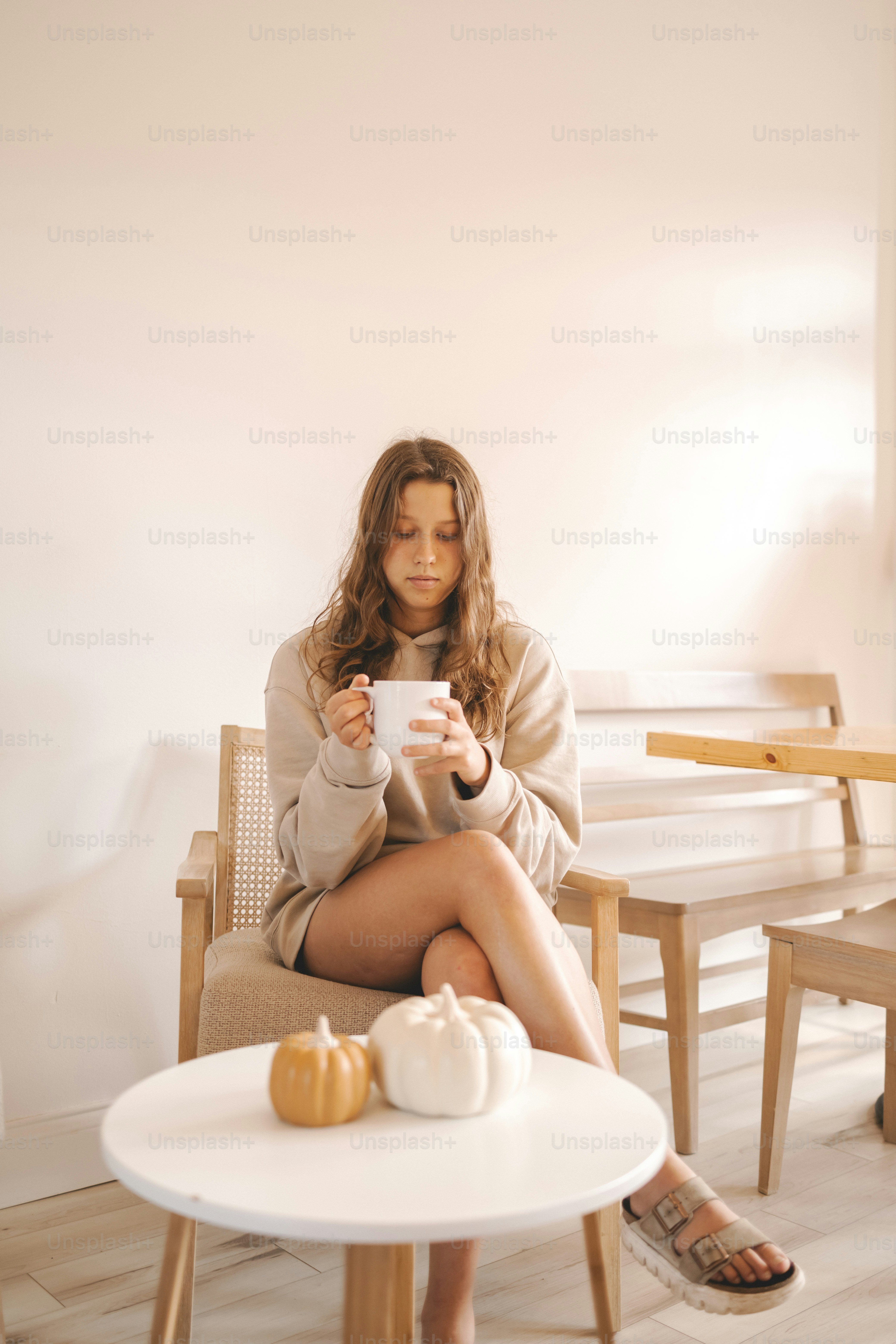 a woman sitting in a chair holding a cup