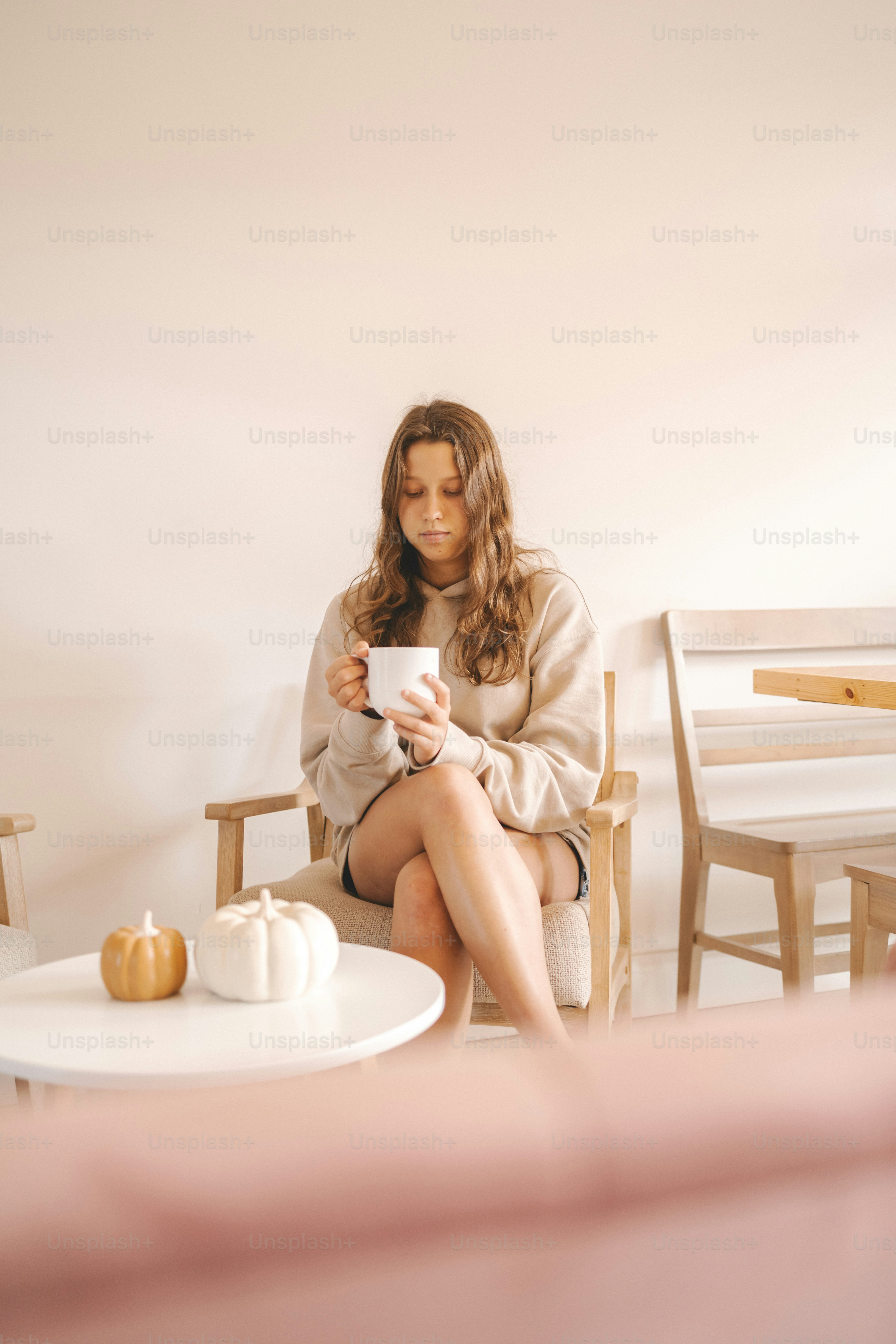 a woman sitting on a chair holding a cup