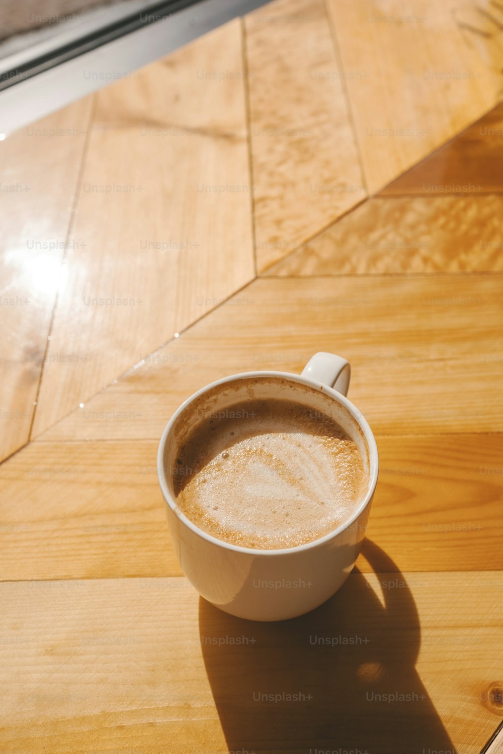 uma xícara de café sentada em cima de uma mesa de madeira