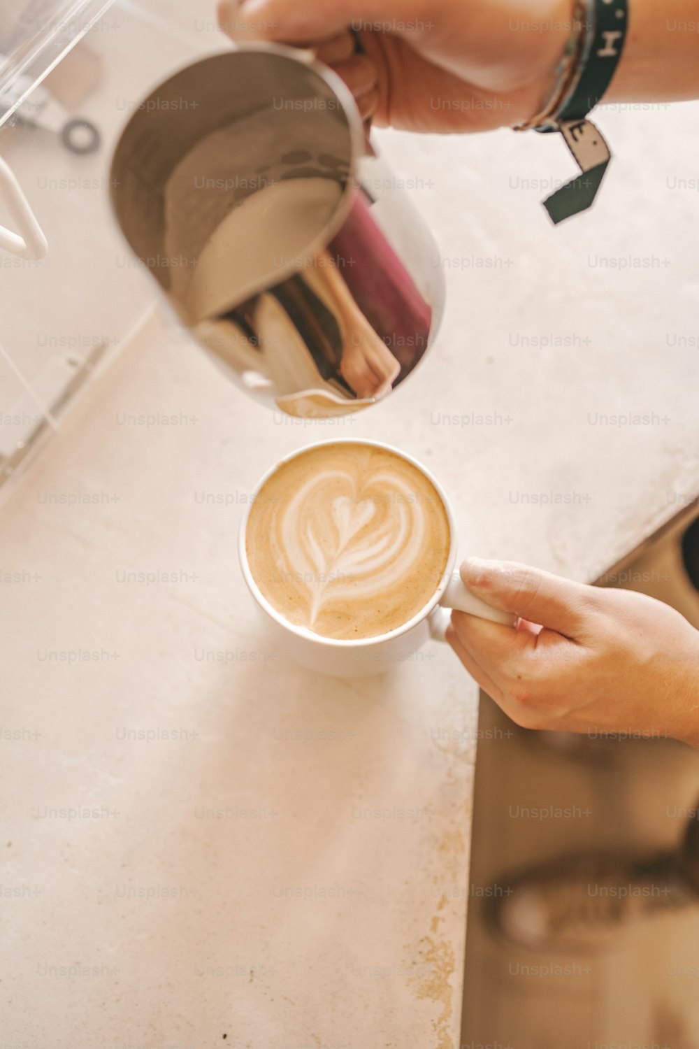 a person pouring a cup of coffee into a cup