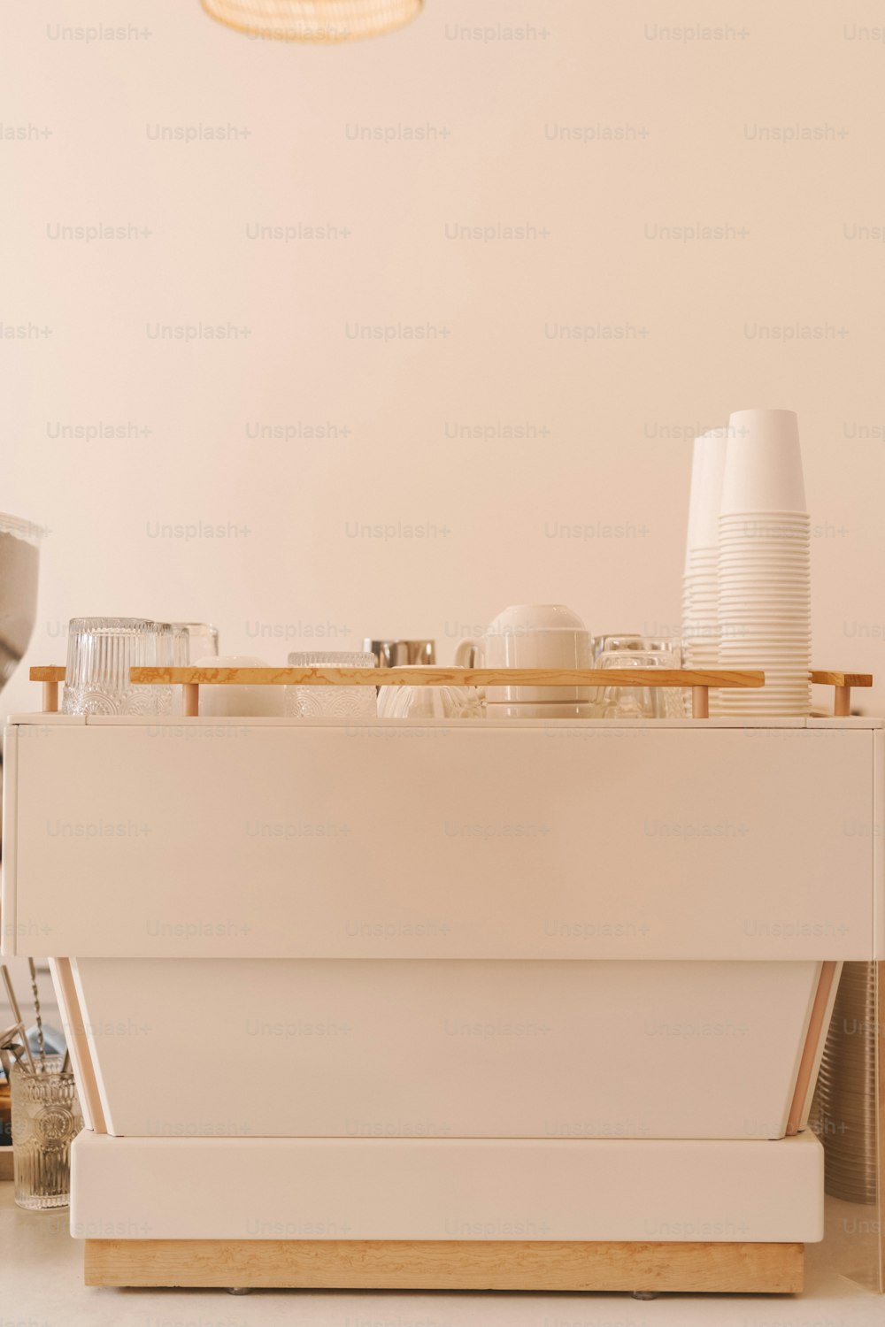 a white counter with plates and cups on it