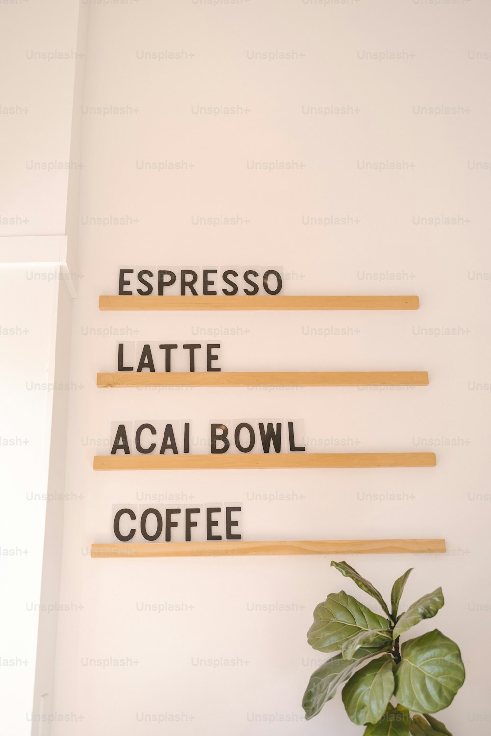 Eine Pflanze sitzt auf einem Tisch neben einem Schild mit der Aufschrift Espresso