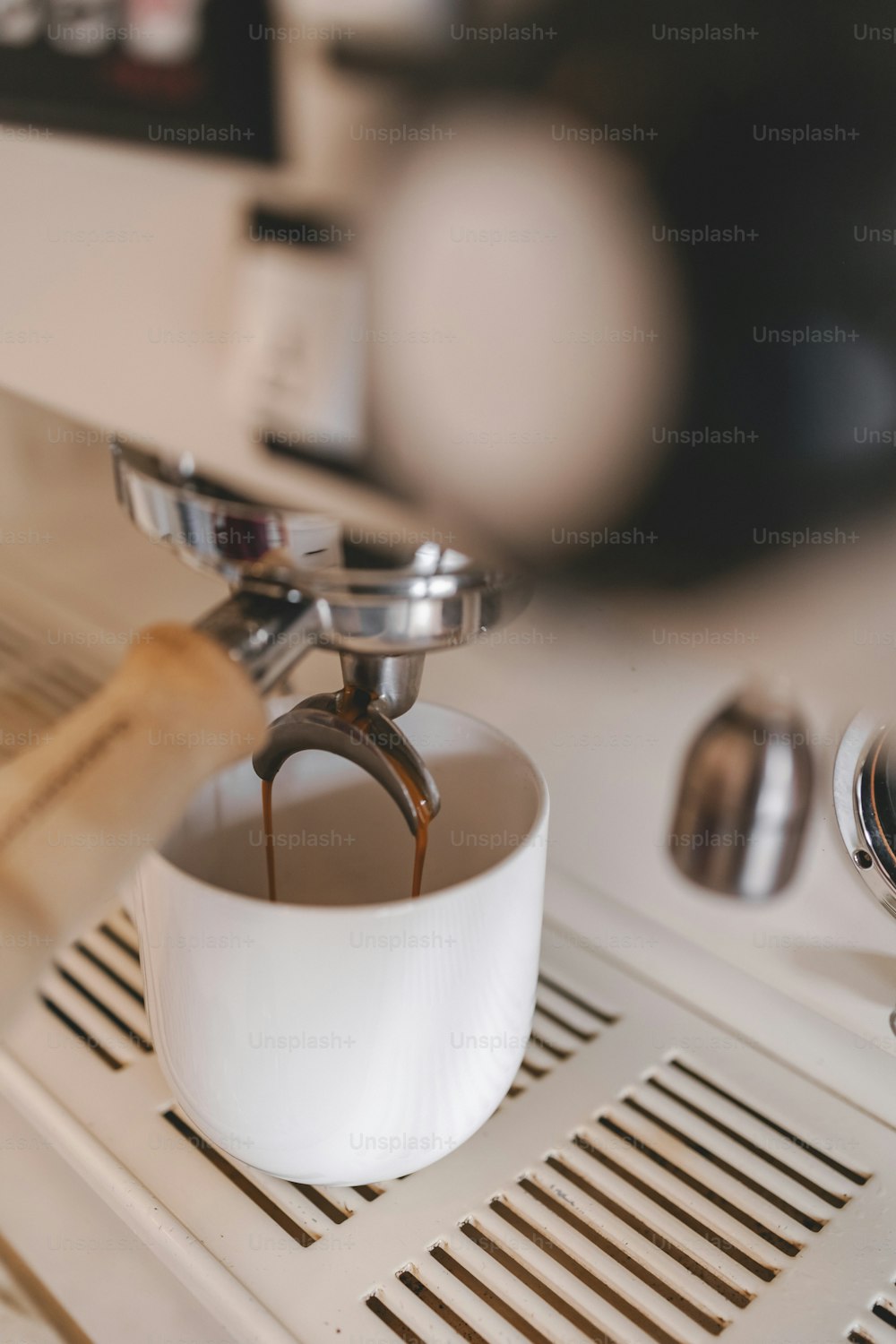 a coffee maker pouring coffee into a cup