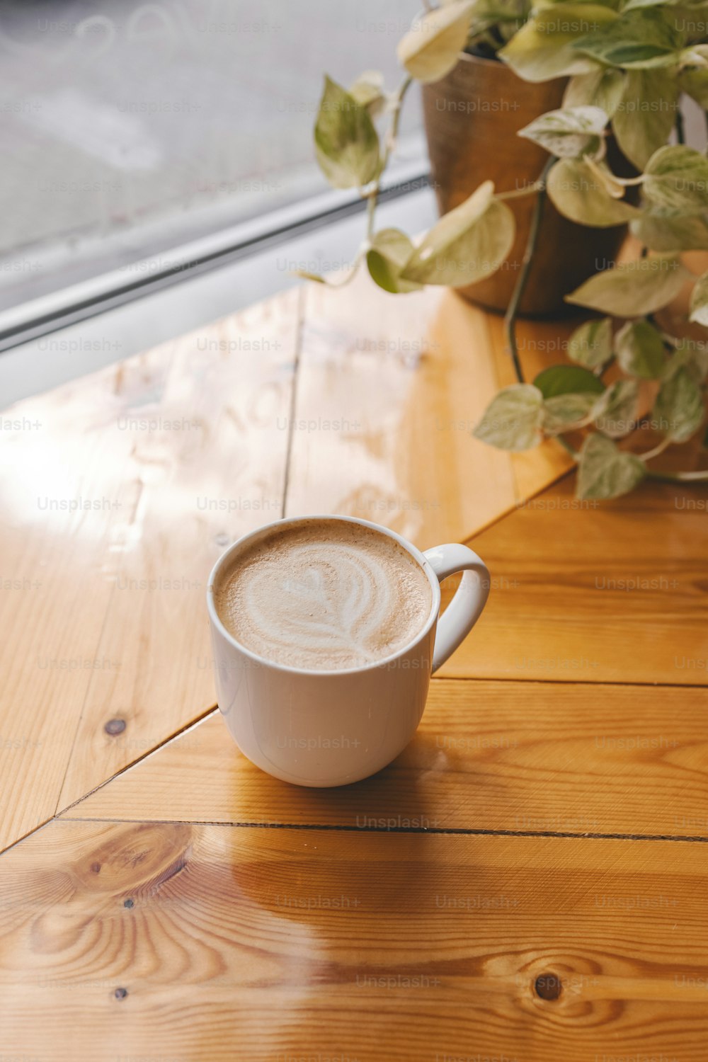 uma xícara de café sentada em cima de uma mesa de madeira