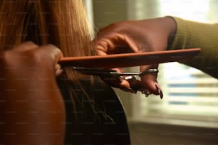 a woman cutting another woman's hair with a pair of scissors