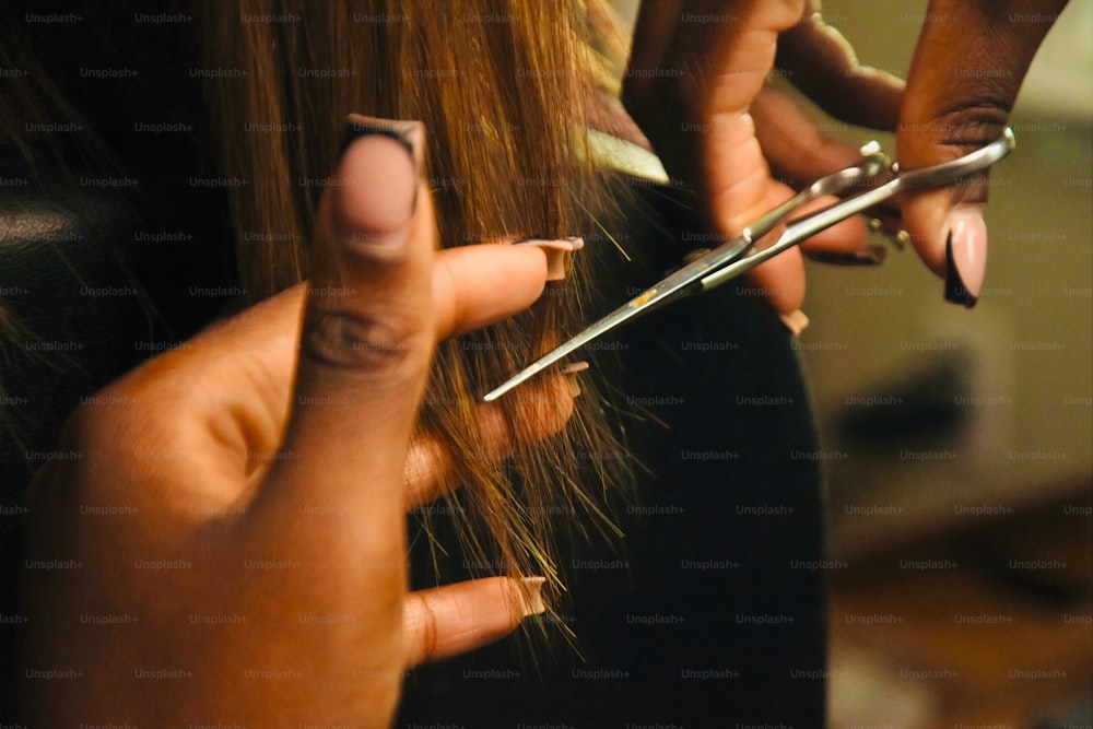 a close up of a person cutting another persons hair