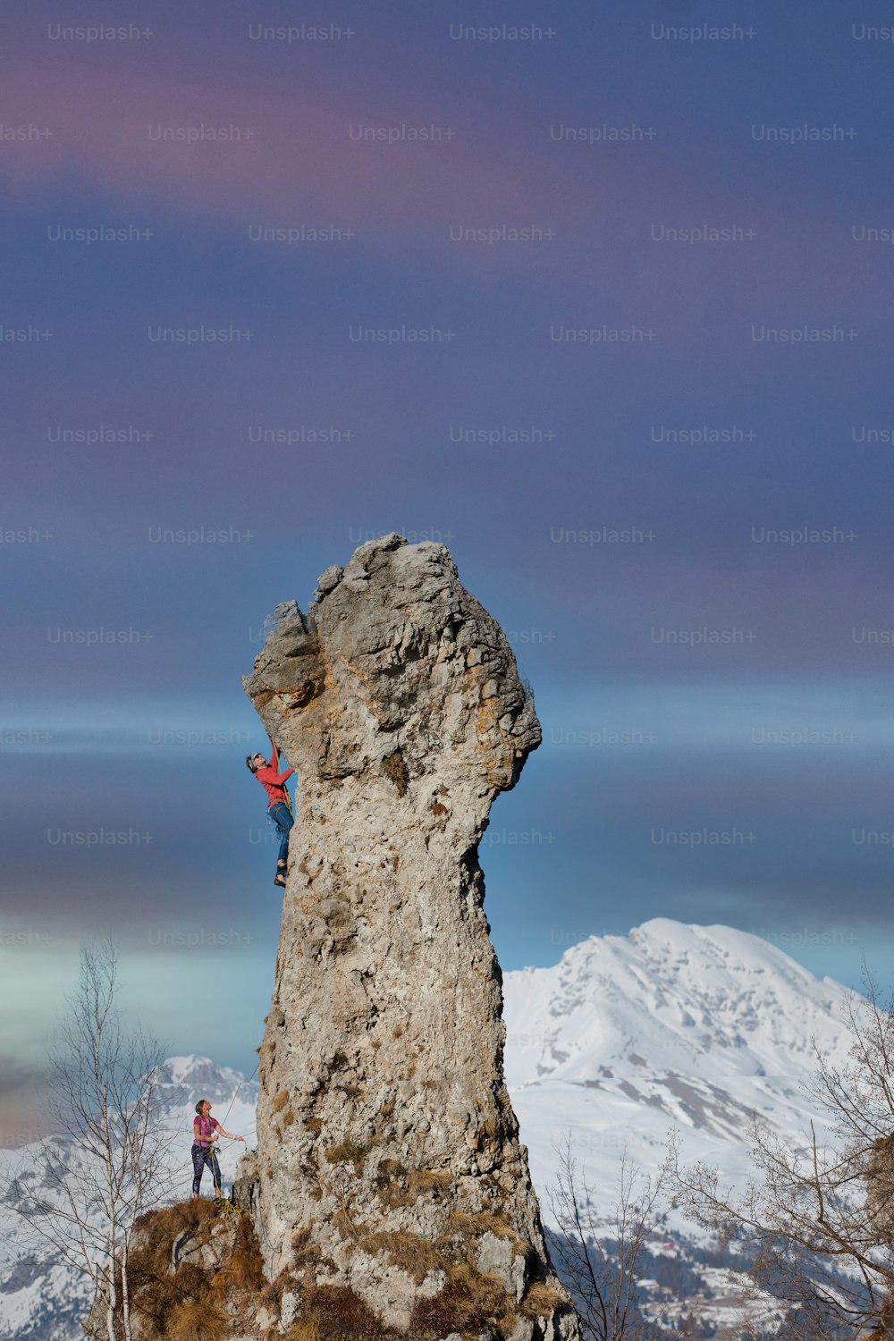 Pic rocheux avec un couple d’alpinistes en cordes