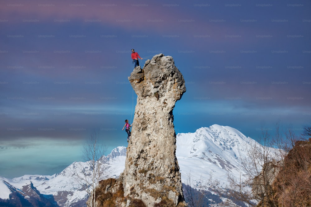 Amarrado por dois alpinistas masculinos e femininos na parede