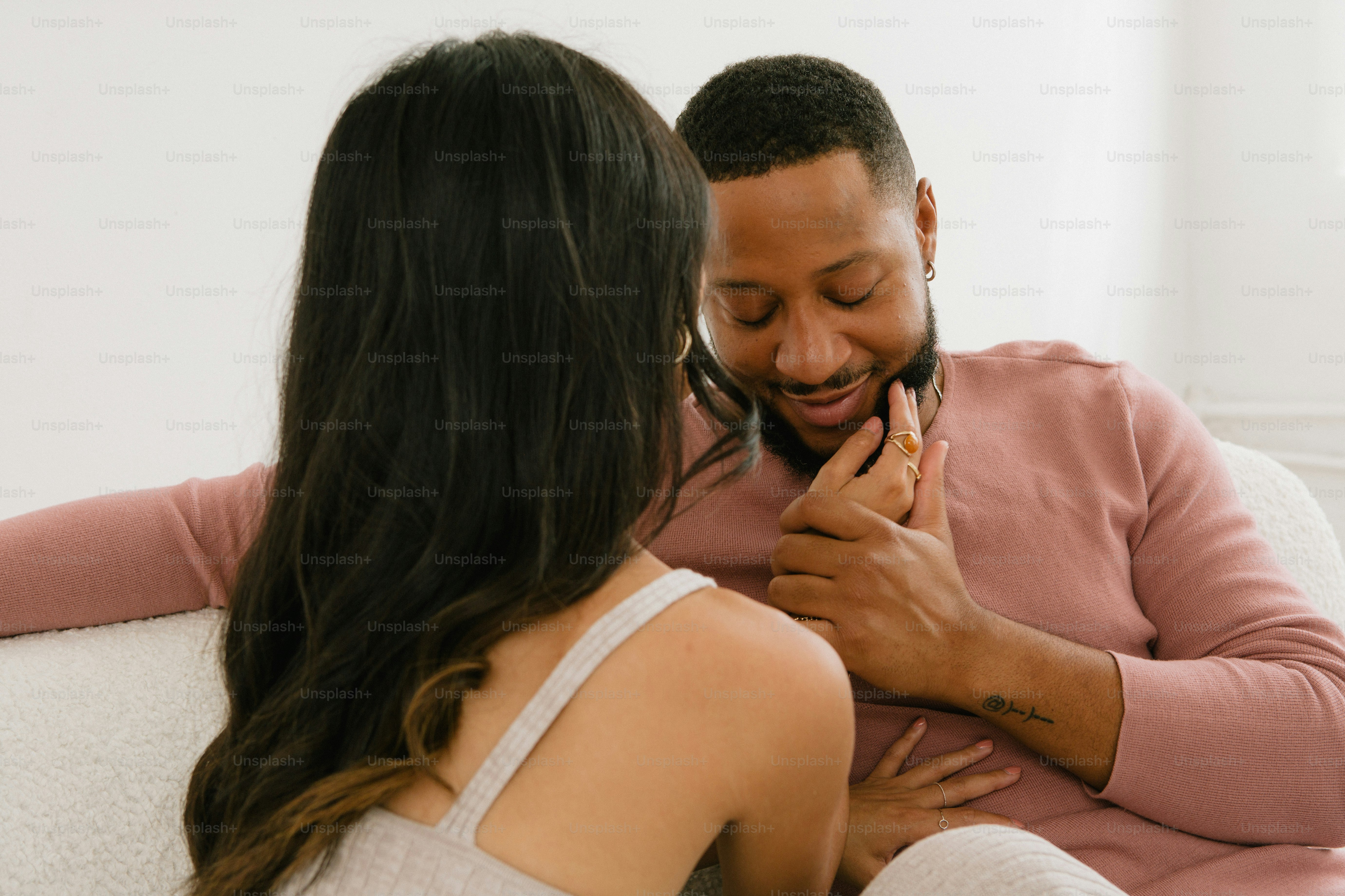 Un uomo e una donna seduti su un divano che si guardano l'un l'altro