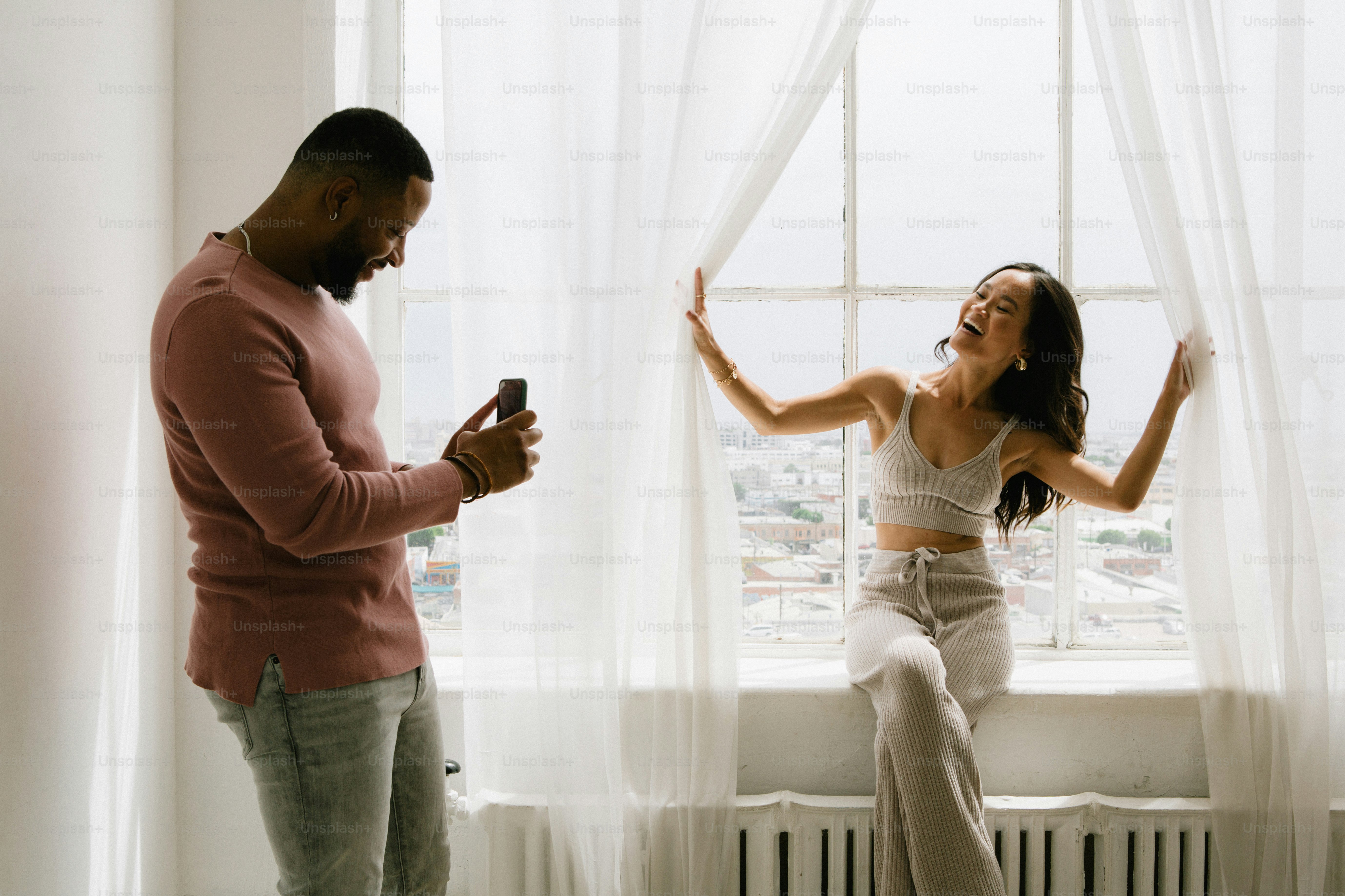 窓の前で女性の隣に立っている男性