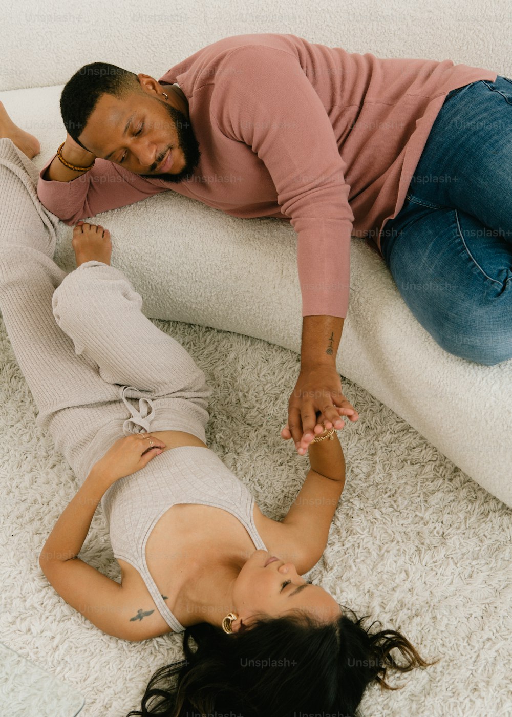 a man and a woman laying on a white couch