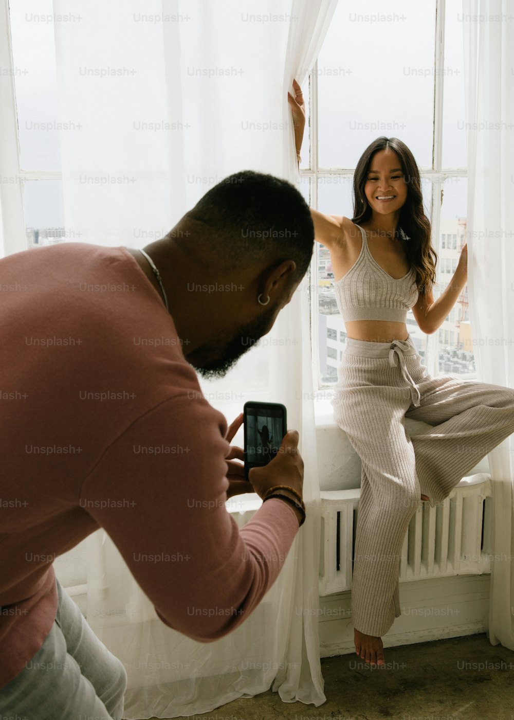 a woman taking a picture of a man in pajamas