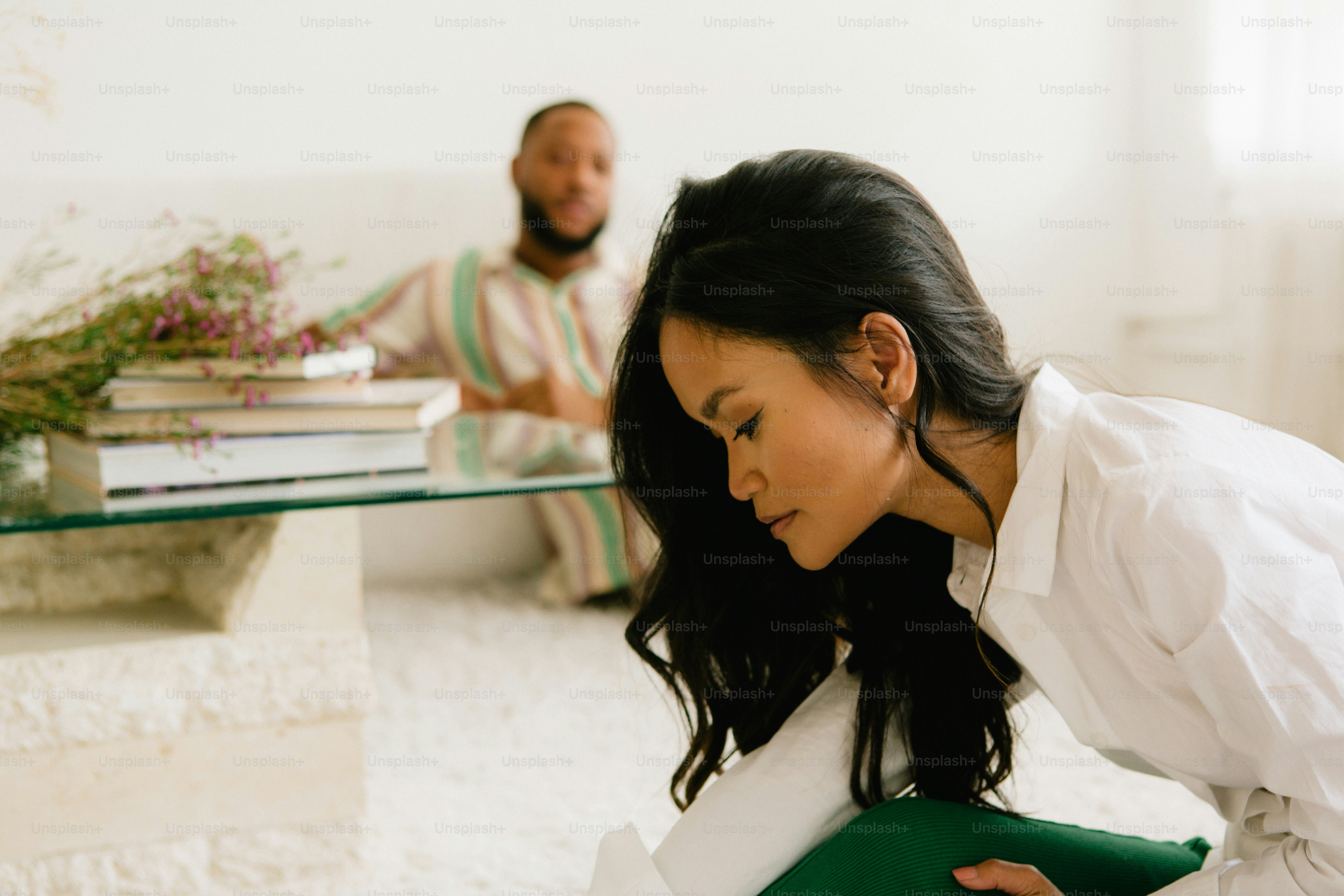 a woman sitting on the floor next to a man