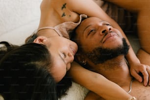 a man and a woman laying on a bed together