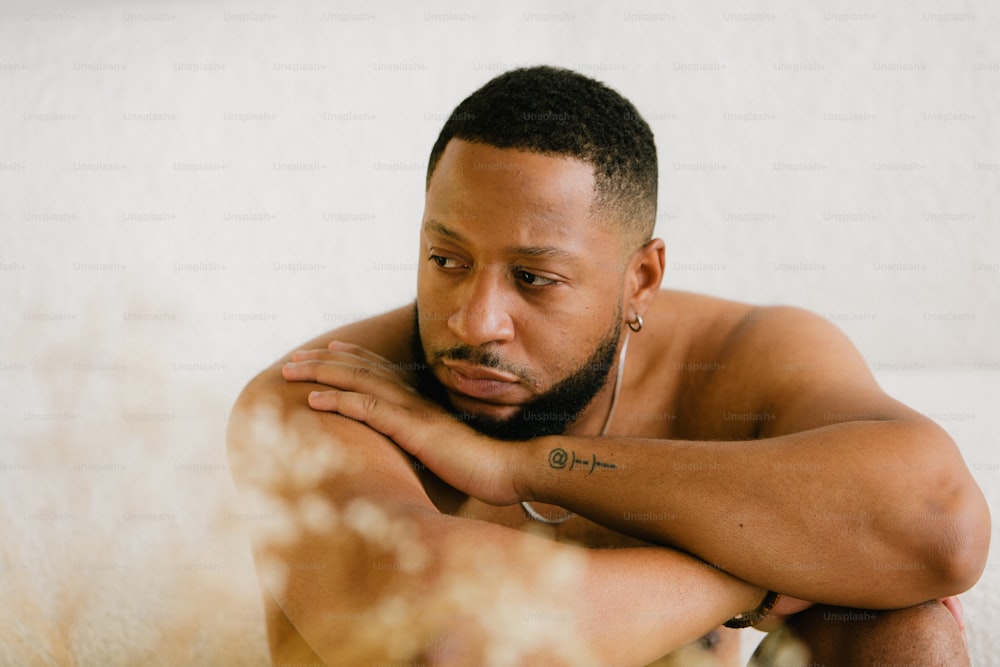 a man with a tattoo on his arm sitting on a couch