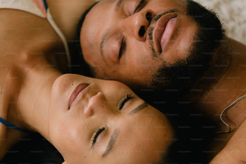 a man and a woman are laying on a bed