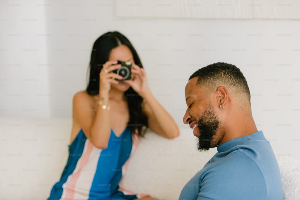 a man taking a picture of a woman with a camera