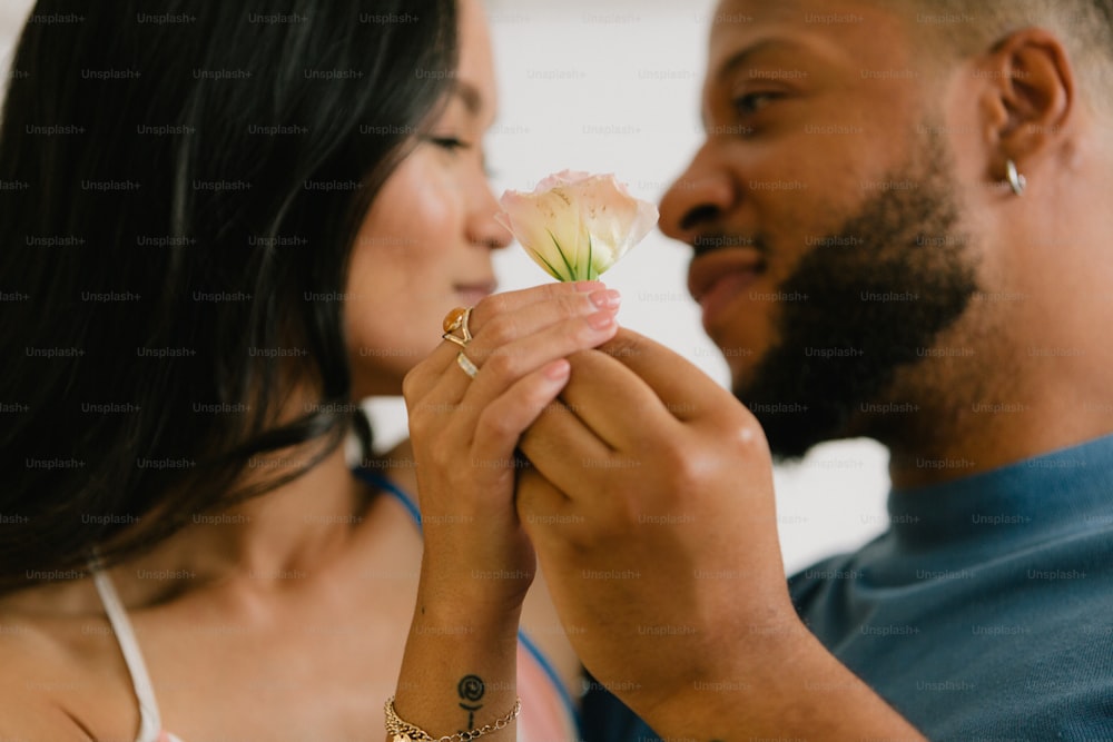 a man and a woman holding a flower together