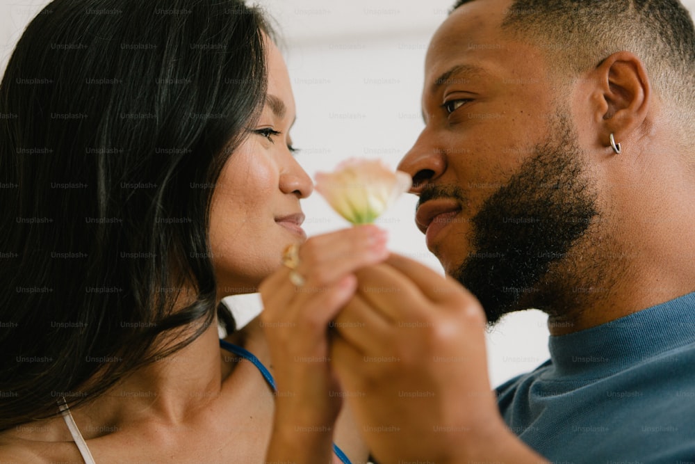a man and a woman holding a flower together