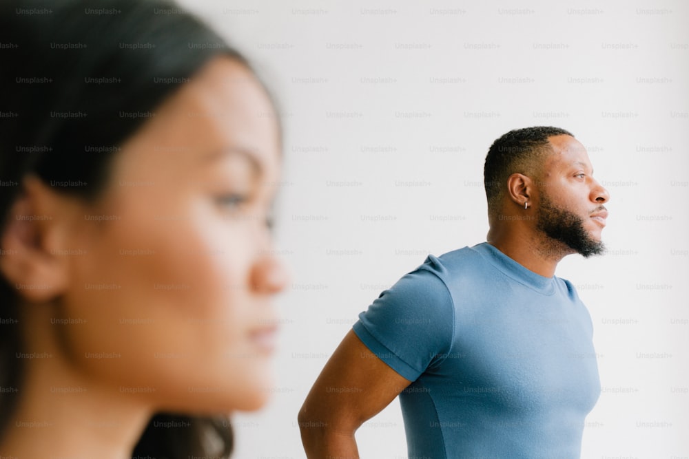 a man standing next to a woman in a blue shirt