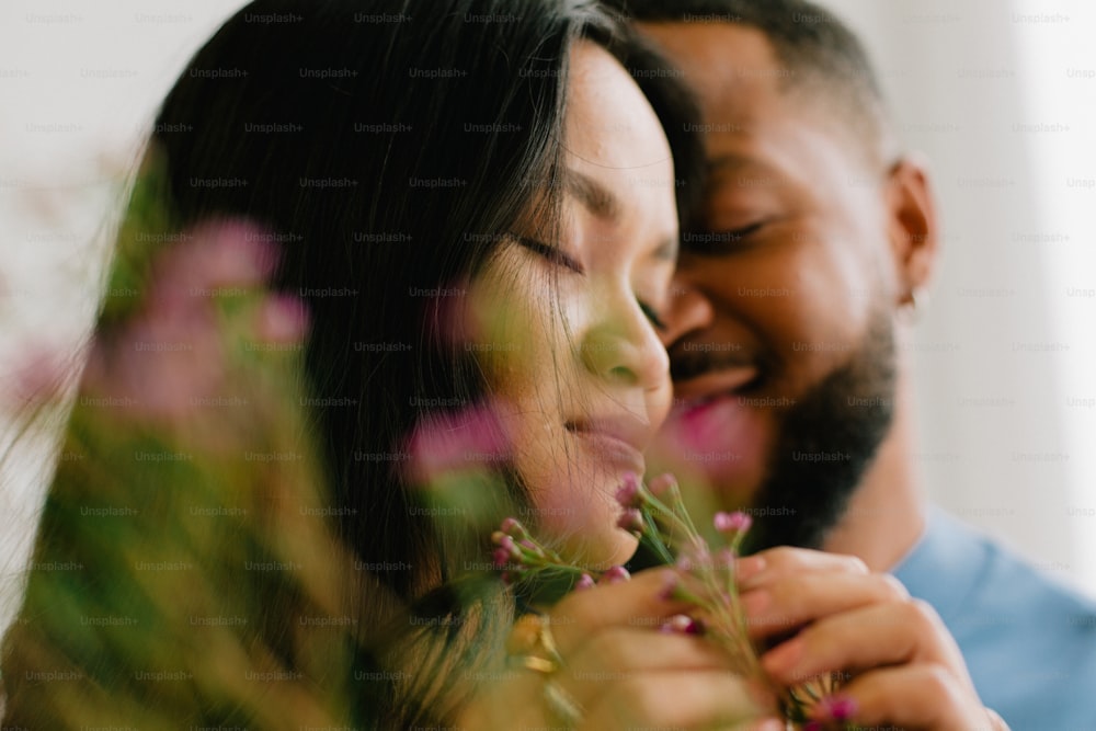 Um homem e uma mulher estão sorrindo e segurando flores