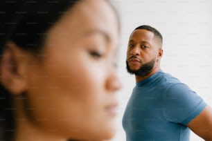 a man standing next to a woman in a blue shirt