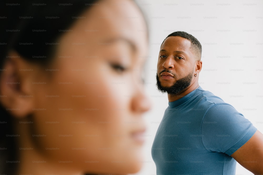 a man standing next to a woman in a blue shirt