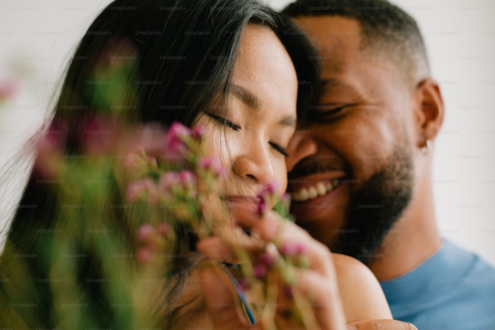 한 남자와 한 여자가 꽃을 들고 웃고 있다