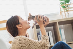 Young Asian woman holding and playing with her cute kitten cat with lovely moment, pet and human concept