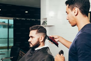 Cliente durante a tosa de barba e cabelo em barbearia