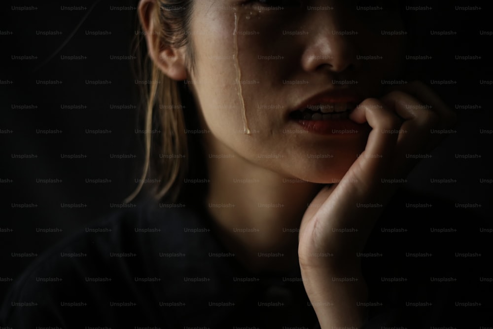 A woman who bites her nails while shedding tears