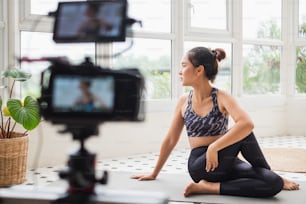 Treinadora asiática fazendo treinamento on-line de transmissão ao vivo e mostrar como exercitar o treino, yoga em casa