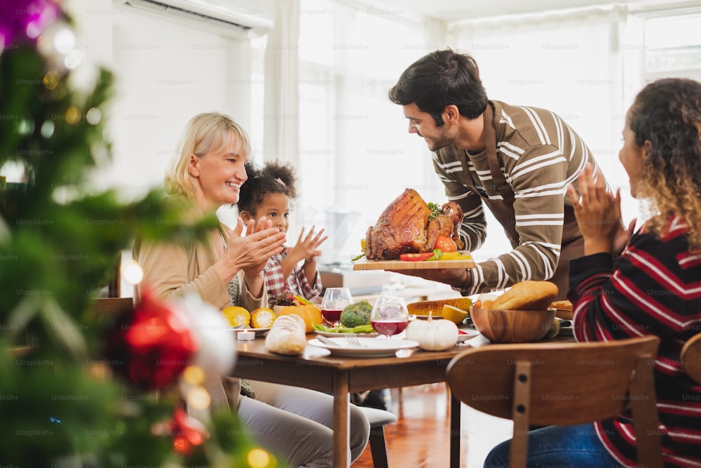家族との幸せな感謝祭のディナーパーティーとテーブルの上に七面鳥の食べ物