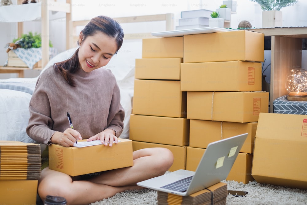 온라인 비즈니스, 온라인 쇼핑, 배송 상자 및 패키지를 위해 집에서 일하는 젊은 아시아 여성