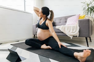 Mulher grávida fazendo exercícios em casa