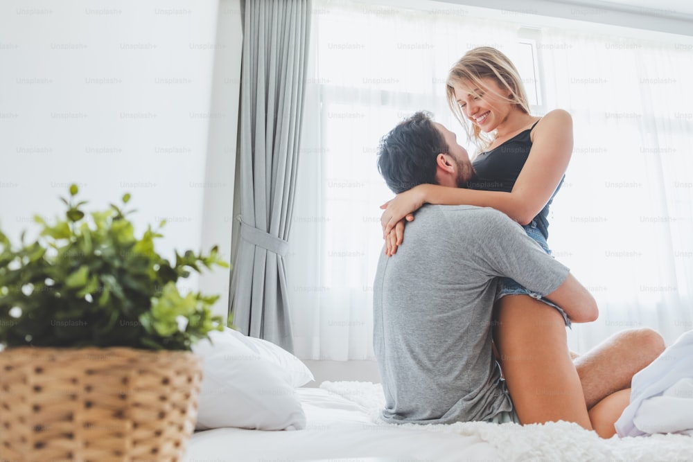 Heureux couple amant sur le lit, câlin et baiser dans le temps romantique, l’amour, le sexe et le concept passionné.