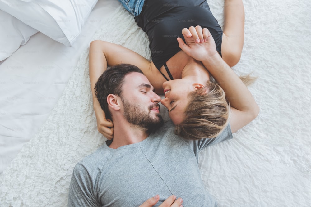 Heureux couple amant sur le lit, câlin et baiser dans le temps romantique, l’amour et le concept passionné.