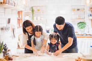 Asian family enjoy playing and cooking food in kitchen at home