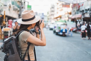 Donna asiatica turista zaino in spalla viaggio e scattare foto in Khao San road, Bangkok, Tailandia