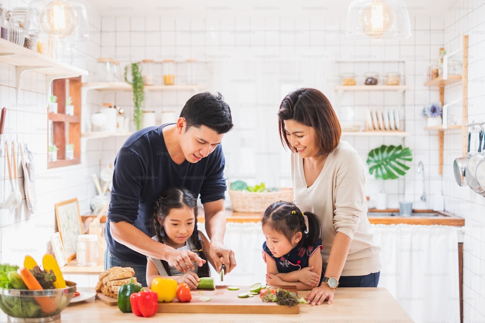 아시아 가족은 집에서 부엌에서 놀고 음식을 요리하는 것을 즐깁니다.