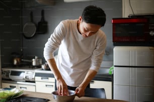 Un homme en train de faire des boulettes de gyoza