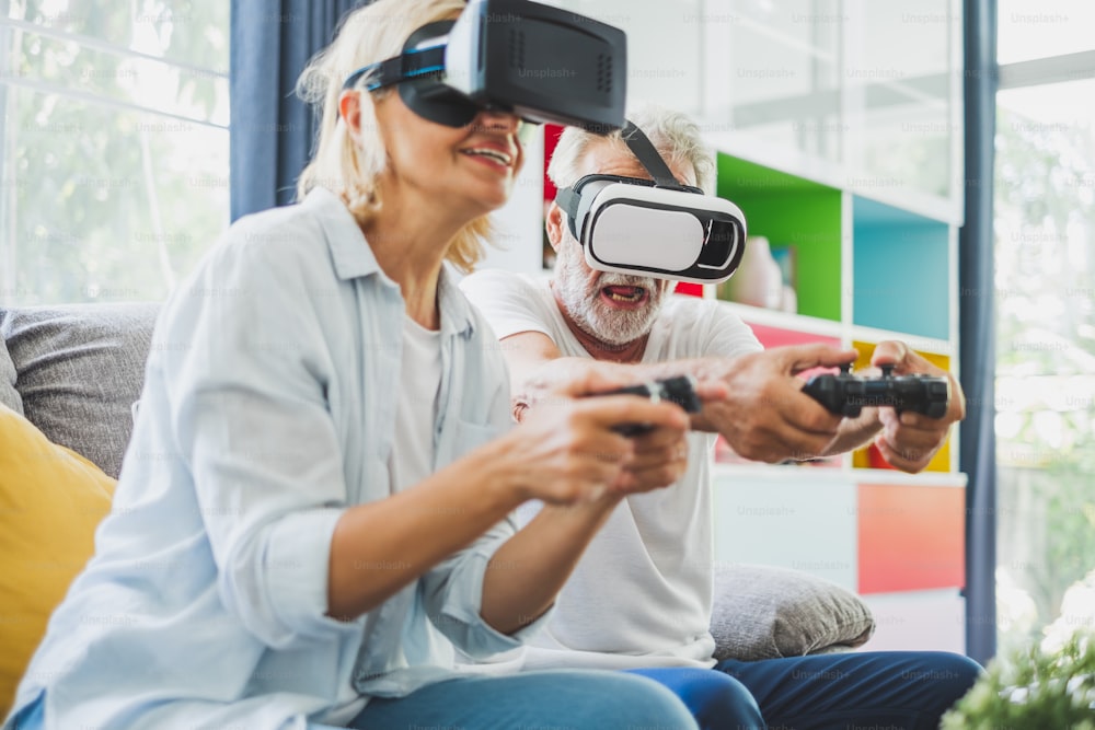 La pareja mayor disfruta jugando juegos de realidad virtual en 3D en casa