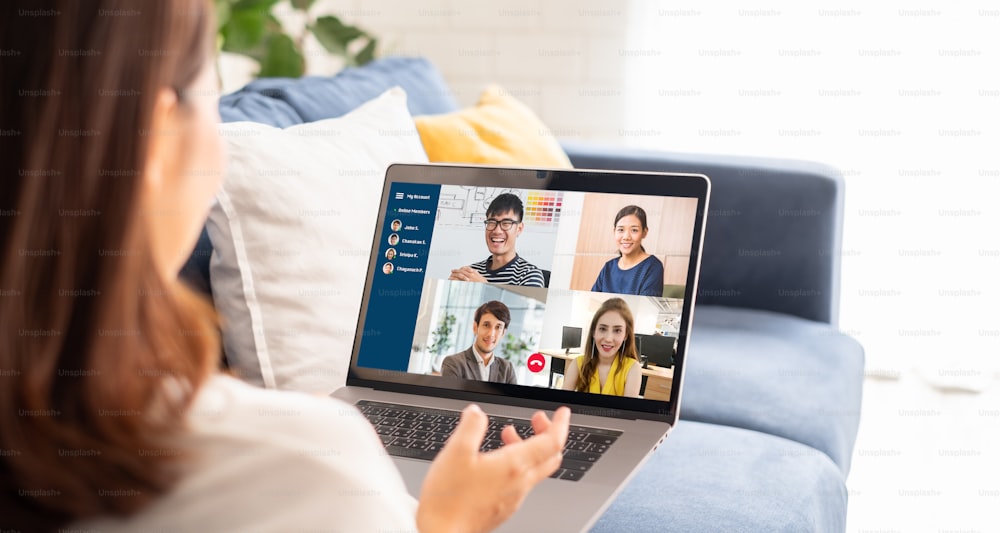 Joven empresaria asiática trabaja en casa y se reúne por videoconferencia virtual con colegas empresarios, trabajo en línea, videollamada debido al distanciamiento social