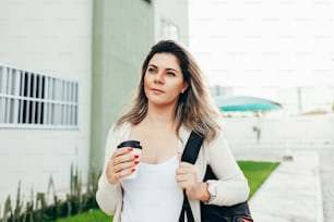 Female student dressed in casual clothing walking around the city